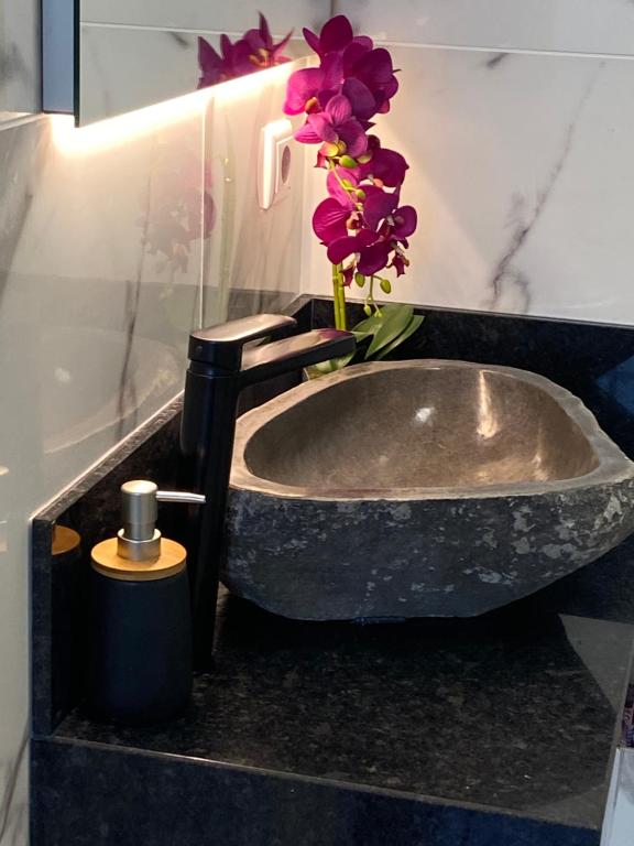 a bathroom sink with a vase with flowers in it at Hollywood villa in Campanário