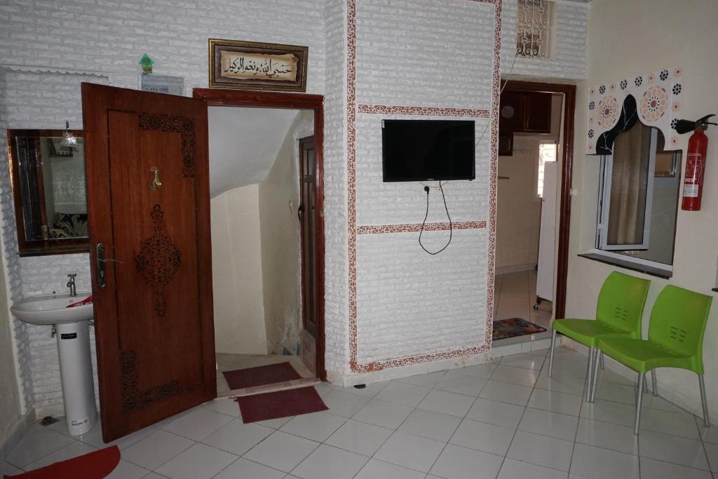 a bathroom with a sink and a tv on a wall at Jinane in Meknès