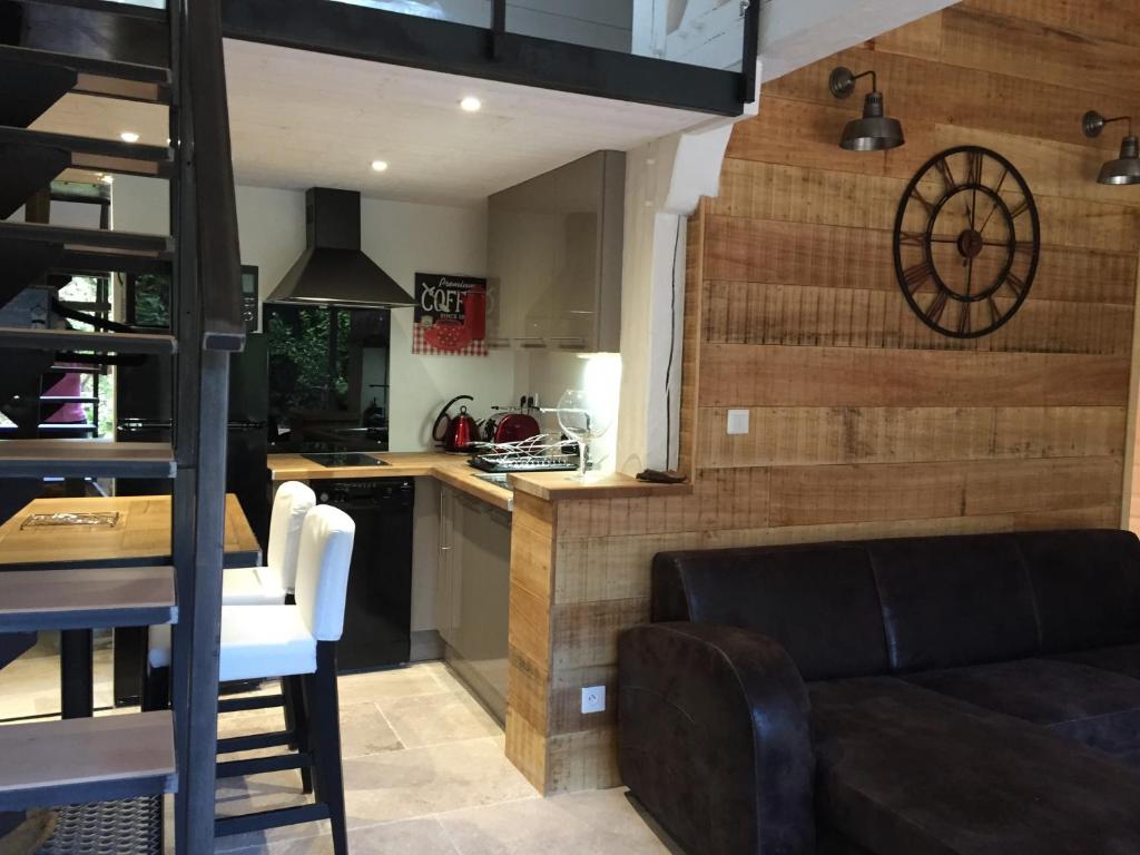 a kitchen and living room with a couch and a table at Le Petit Paradis in Honfleur