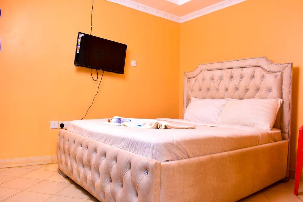 a bedroom with a bed with a tv on the wall at Consular Resort Meru in Meru