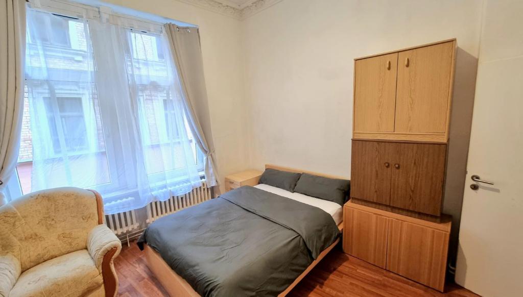 um quarto com uma cama, um armário e uma janela em Studio Apartement in Halle em Halle an der Saale