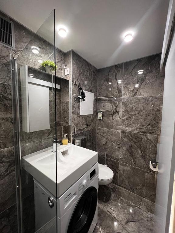 a bathroom with a sink and a toilet and a shower at Liepājā 4:10 pm in Liepāja