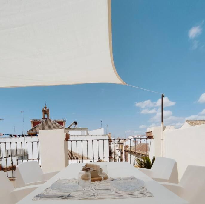 einen weißen Tisch und weiße Stühle auf dem Balkon in der Unterkunft Antigua Casa Hermandad in Sevilla