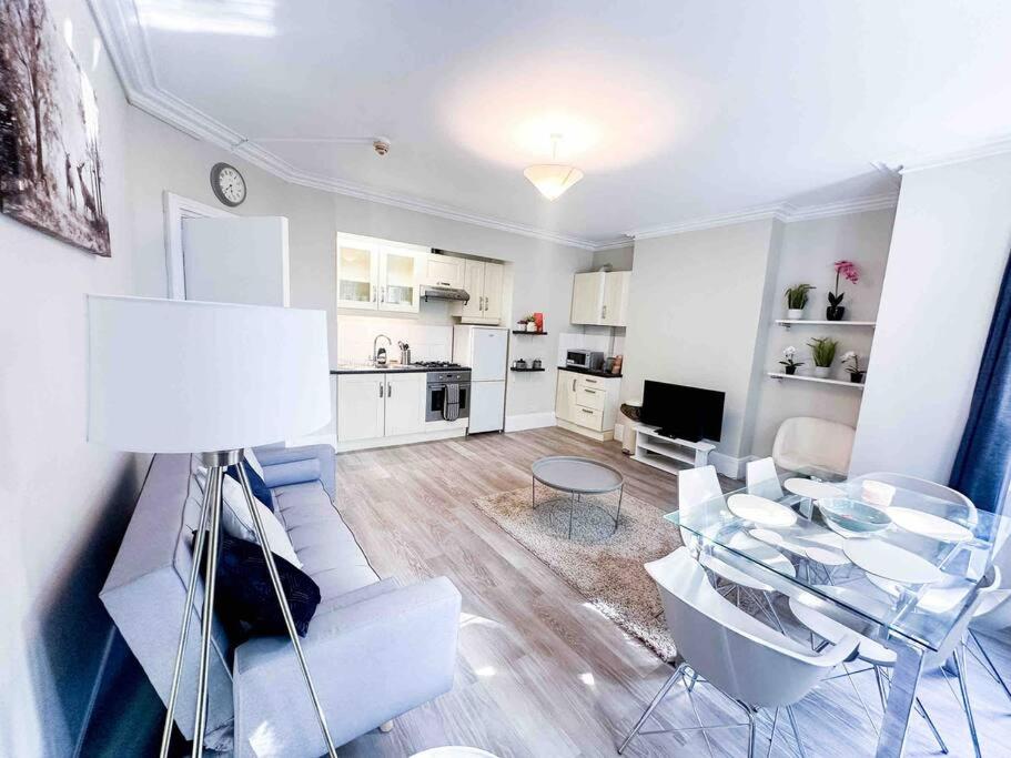 a living room with a table and chairs and a kitchen at Reading Spacious Stay, NHS & Contractors in Reading