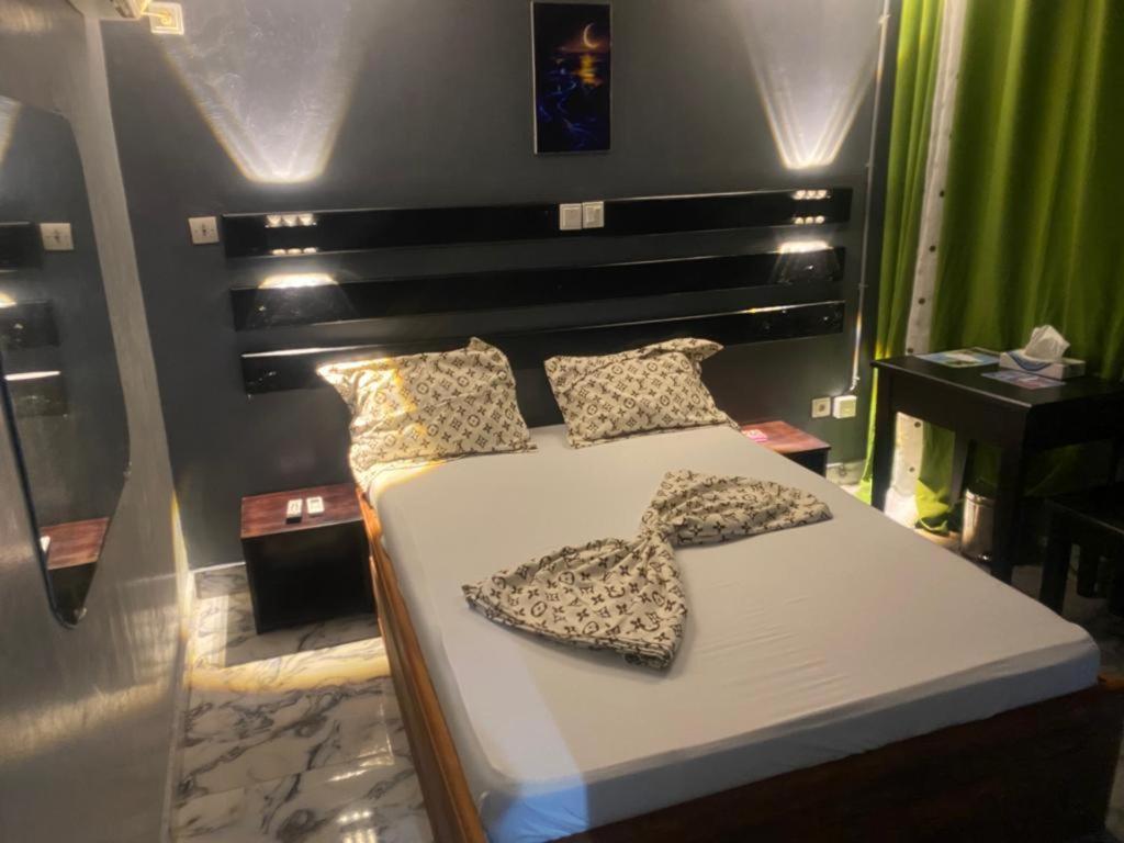 Un dormitorio con una cama con dos zapatos. en Sunrise Center Bonapriso - 109 en Duala