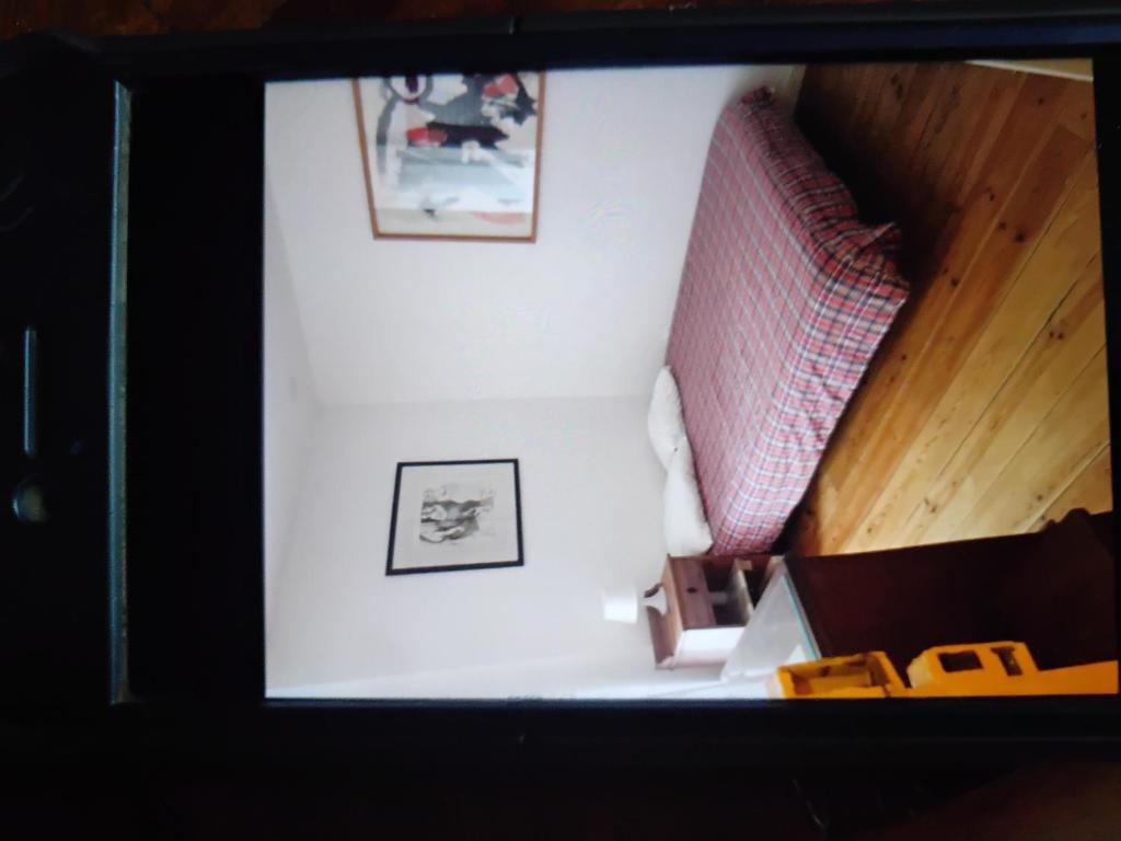 een kamer met twee foto's aan de muur en een trap bij Tiny cosy flat in Lissabon