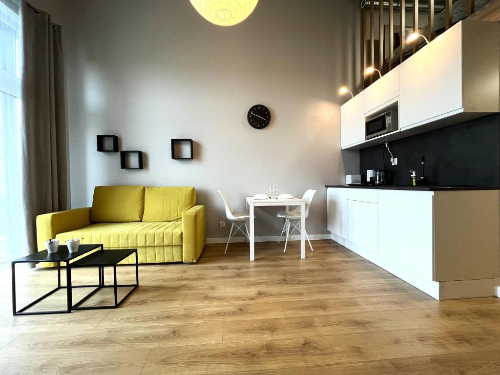 uma sala de estar com um sofá amarelo e uma mesa em Zarembowicza 31 Apartment - Self Check-In 20h - Lift em Breslávia