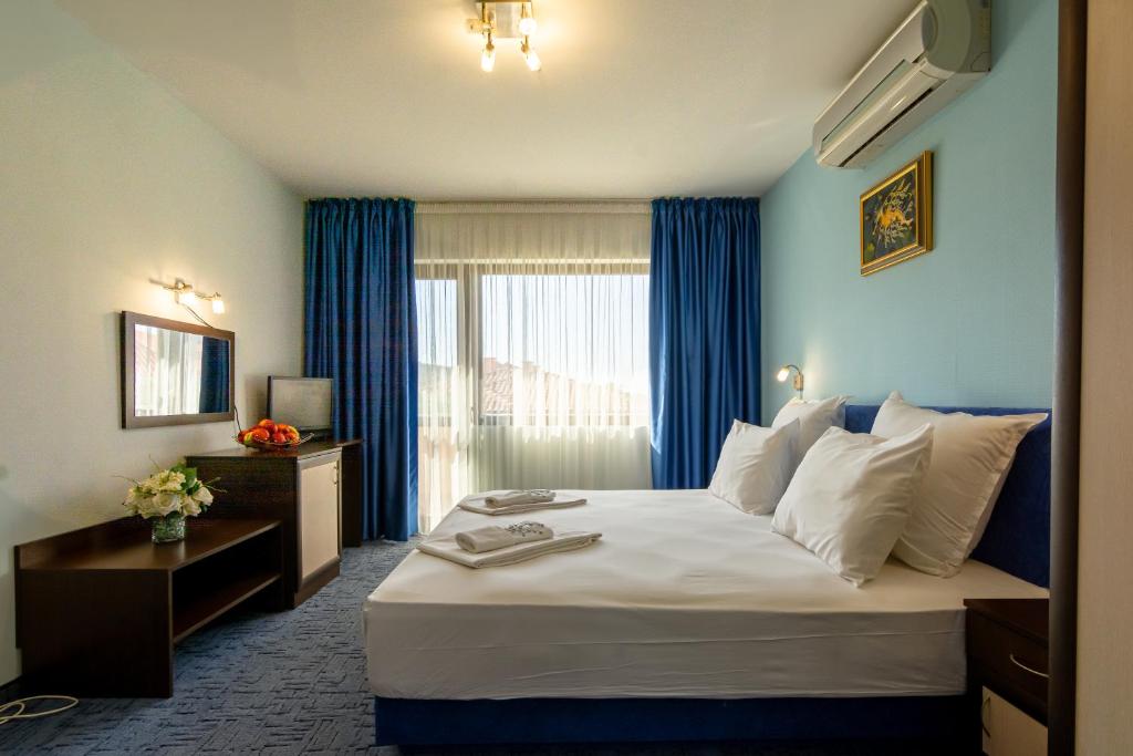 ein Hotelzimmer mit einem großen Bett und einem Fenster in der Unterkunft Saint George Mountain Residence in Belashtitsa