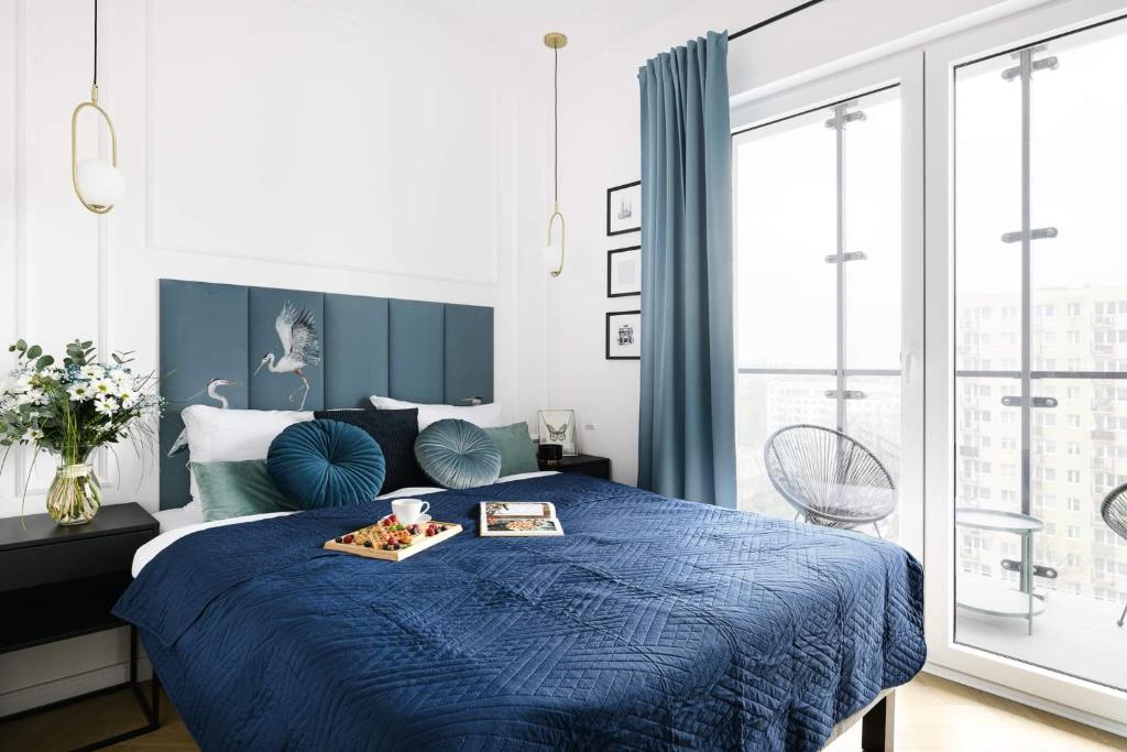 ワルシャワにあるLuxury Design Apartments - Warsaw Tower Bliska Wolaのベッドルーム1室(青いベッド1台、食料トレイ付)