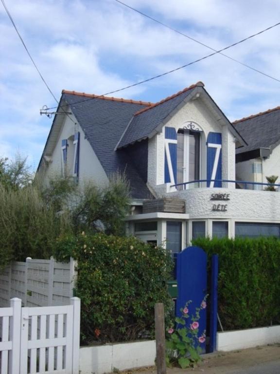 une maison avec des fenêtres bleues et une clôture blanche dans l'établissement Charmante maison entre Marché et Tourelles, à Pornichet