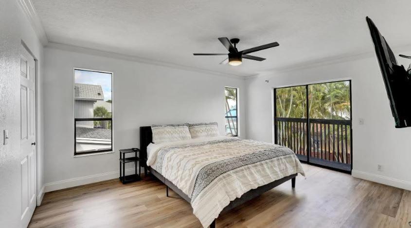 a bedroom with a bed and a ceiling fan at Delray Escape Pool Renovated Sleeps 12 in Delray Beach