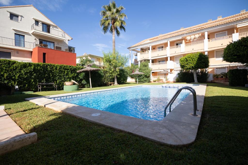 a swimming pool in a yard next to a building at Jávea terraza + piscina + vistas al mar in Platja de l'Arenal