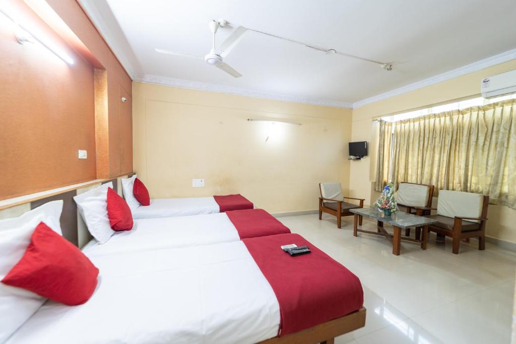 a bedroom with a large bed with red pillows at Hotel Surya Residency Majestic in Bangalore