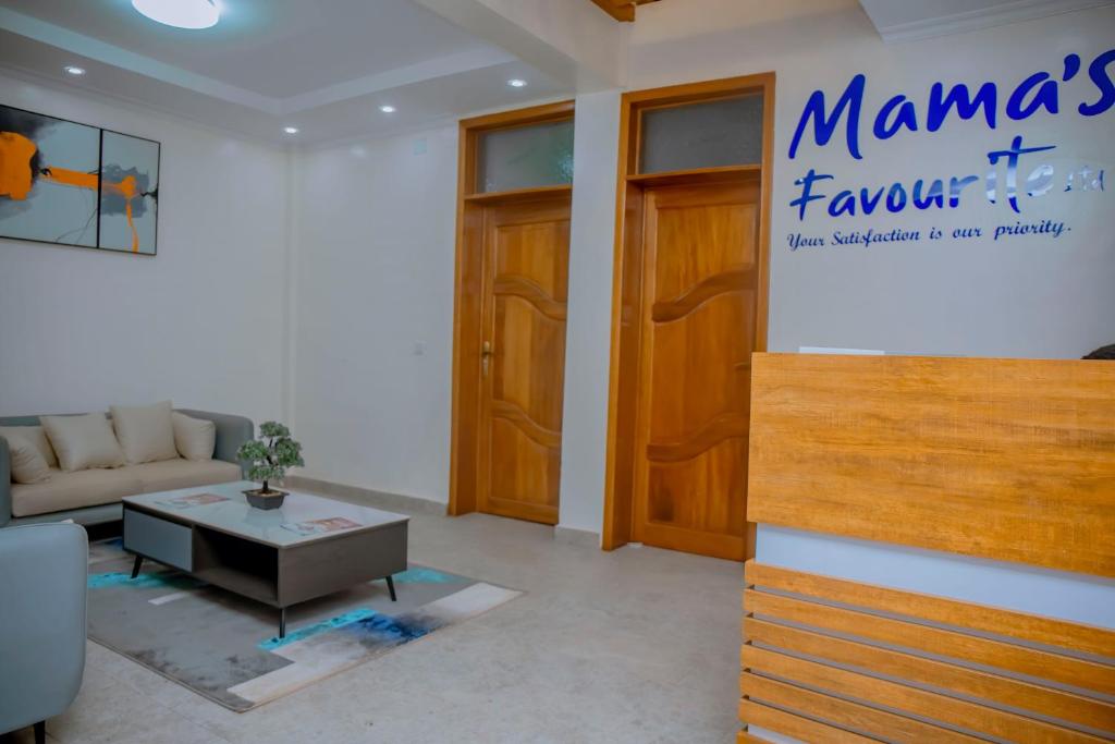 Mama's Favourite Apartments في كيغالي: غرفة معيشة بها أريكة وطاولة