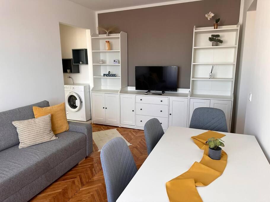 a living room with a couch and a table and a tv at Lux Apartment Vivo Mall in Baia Mare