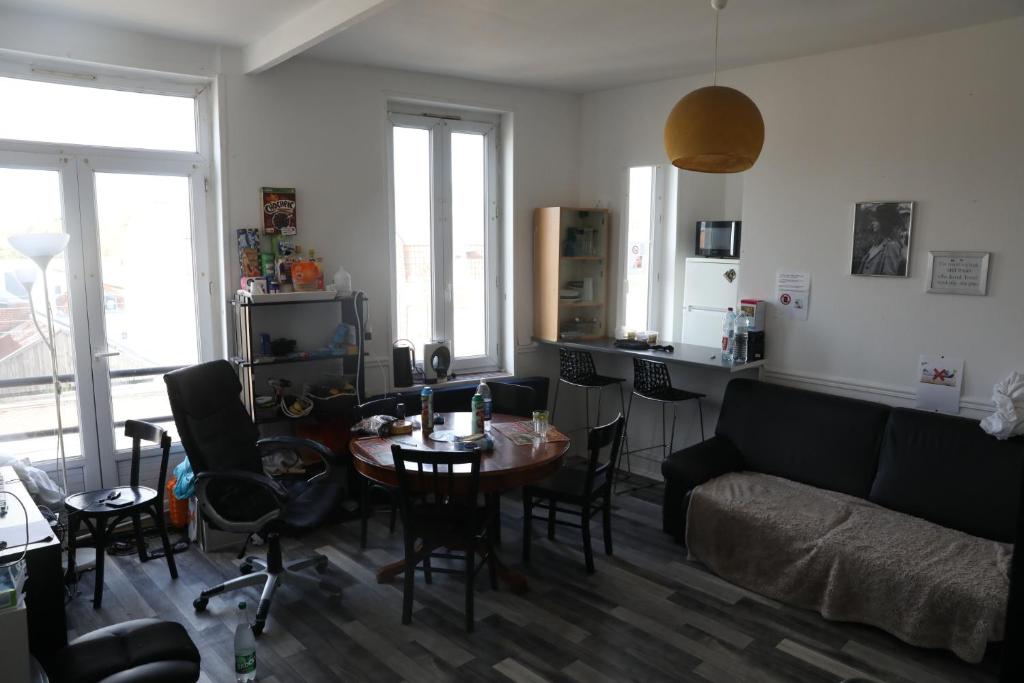 a living room with a table and a couch at Appartement spacieux Lille in Lille