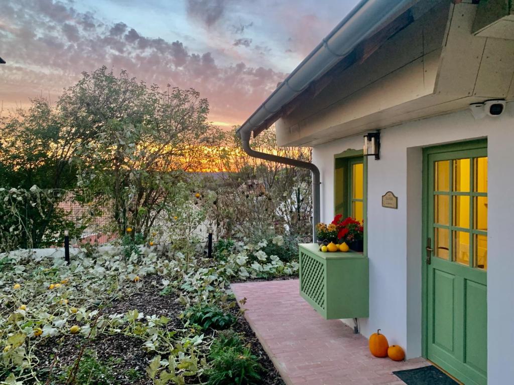 una casa con una puerta verde y un jardín con calabazas en Pannonhalma Várlak Vendégház Demeter Lak, en Pannonhalma