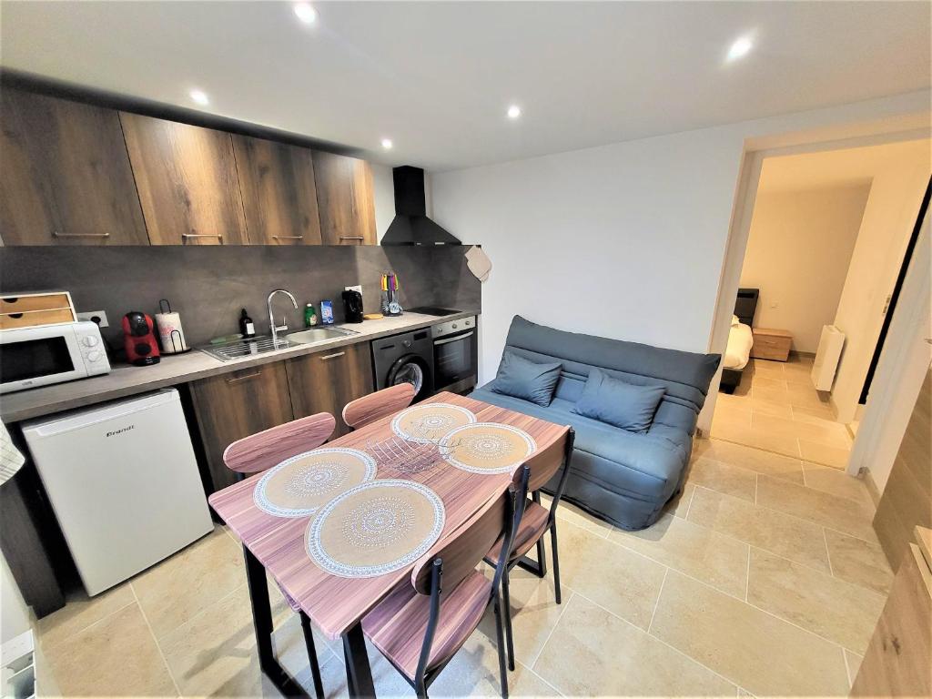a kitchen with a table and a couch in a room at Joli T2 1er étage wifi/verdon/centre ville in Castellane