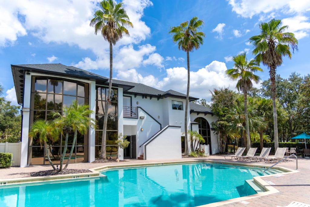 uma piscina em frente a uma casa com palmeiras em Legacy Vacation Resorts - Disney and Lake Buena Vista em Orlando