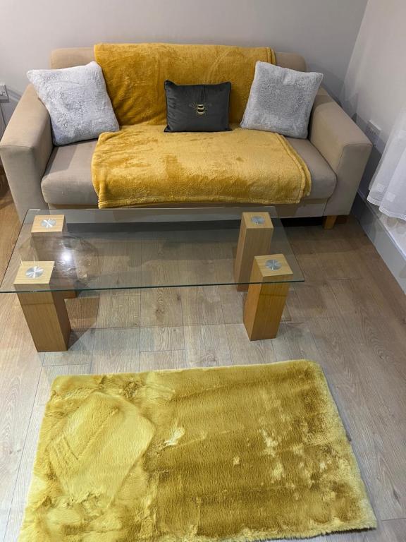 uma sala de estar com um sofá e um tapete amarelo em Stonebarn Lane em Halton