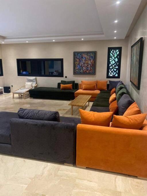 een grote woonkamer met banken en tafels bij Villa Soleil 4 chambres in Marrakesh