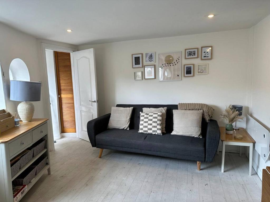un soggiorno con divano blu e tavolo di Cozy 1 Bedroom Flat The Snug a Kent