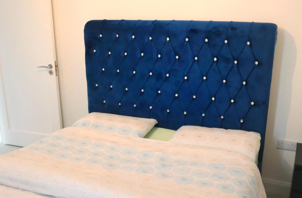 a bed with a blue headboard in a room at Your Perfect Home Away from Home in Cork