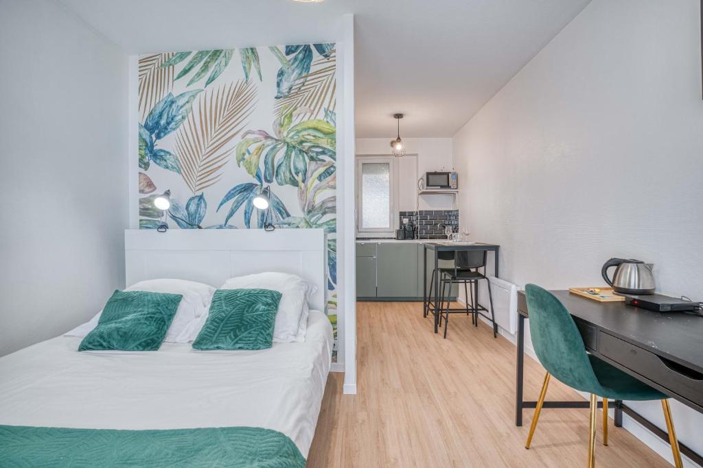 1 dormitorio con cama, escritorio y cocina en Élégant studio centre Marmande Mon Petit Appart en Marmande