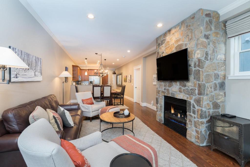 una sala de estar con chimenea de piedra en River Club 203 by Alpine Lodging Telluride, en Telluride