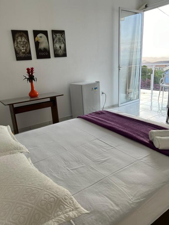 1 dormitorio con 1 cama blanca grande y ventana en SUITE ELEGACY en Serra de São Bento