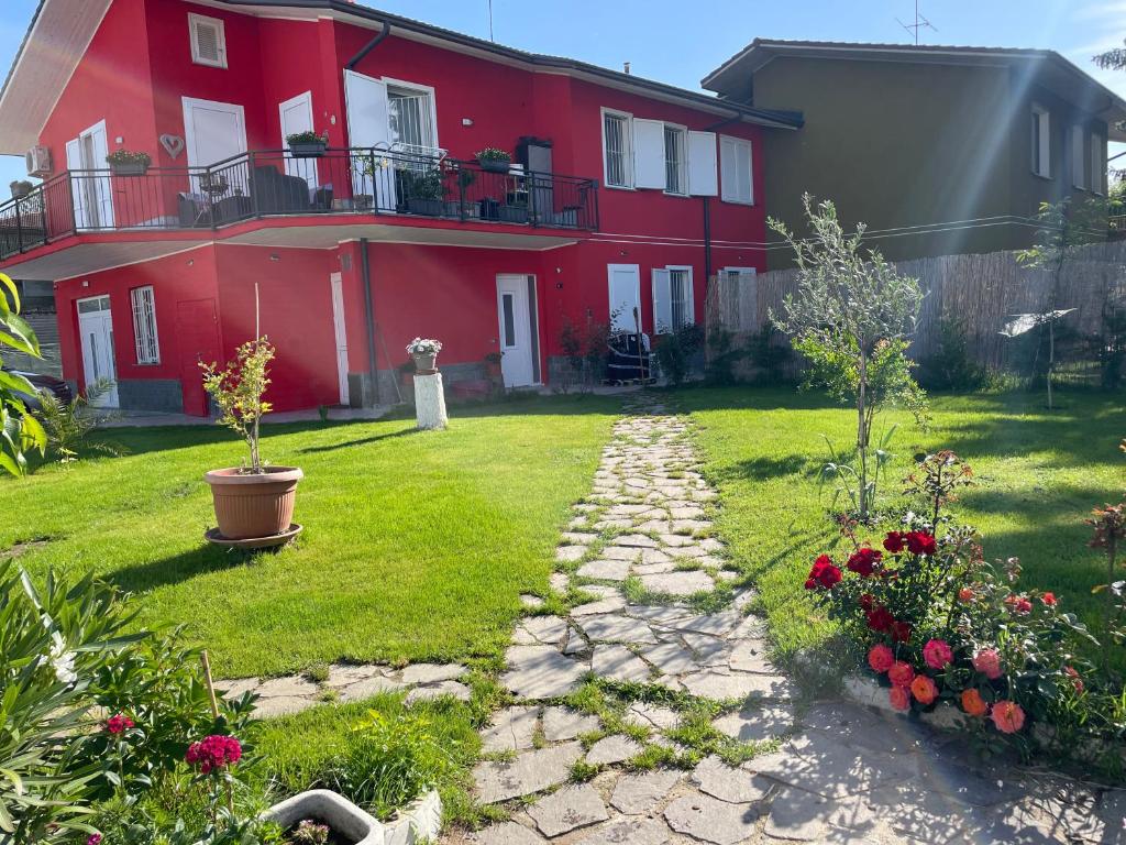 una casa roja con un camino de piedra en el patio en Casa Rossa, en San Leonardo