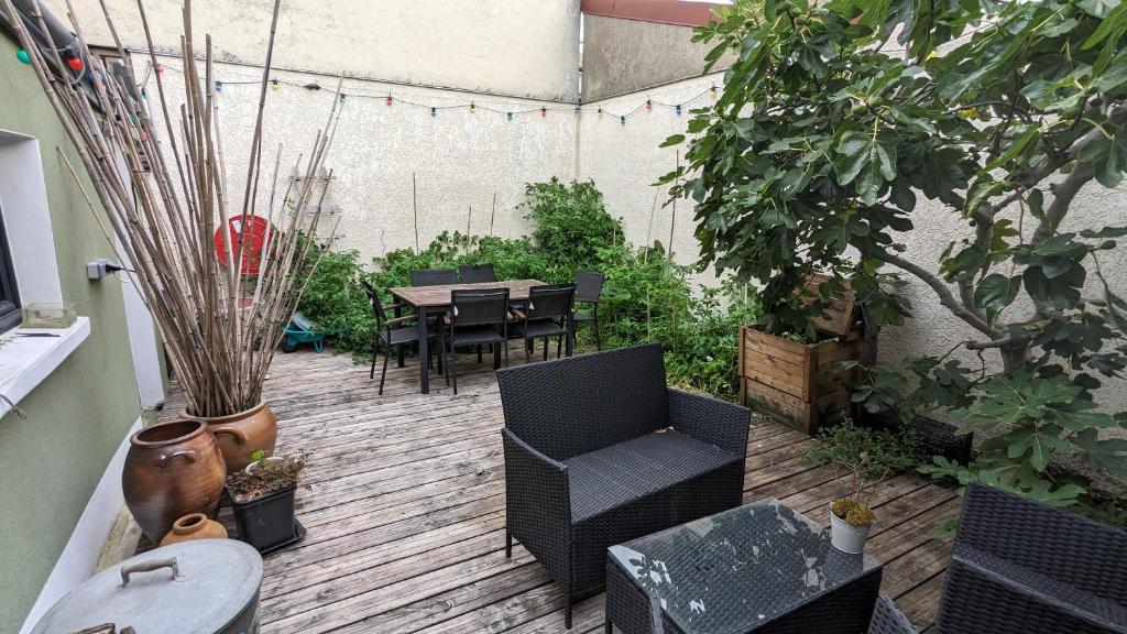 un patio con mesa, sillas y plantas en "Maison verte" - terrasse - parking - 10min du métro en Montreuil