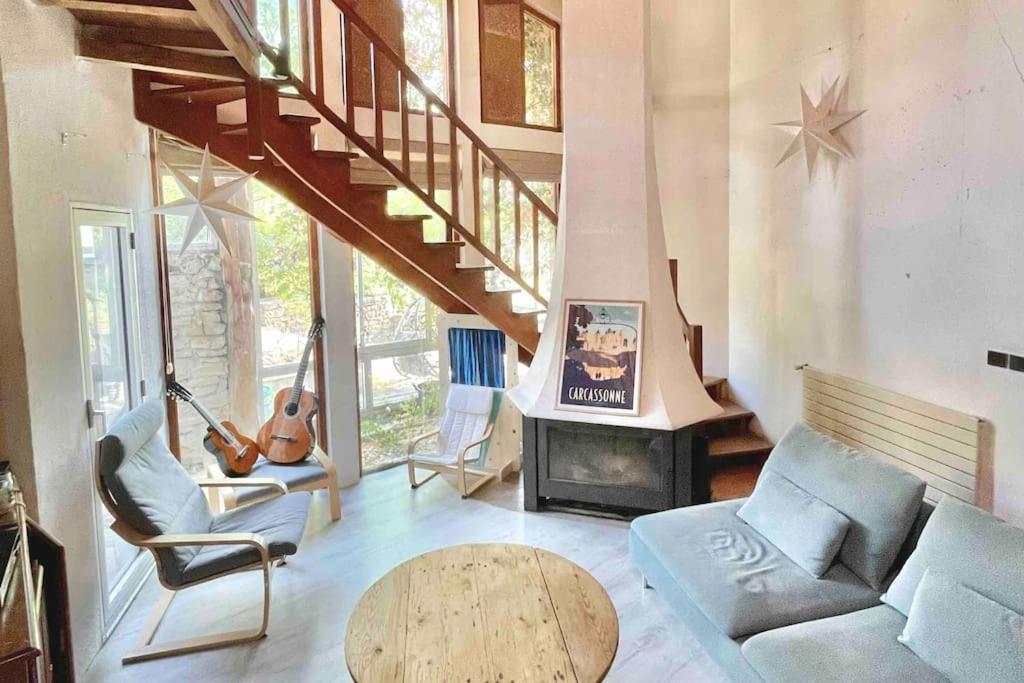 un salon avec un canapé et une cheminée dans l'établissement Maison d’archi 80’s avec piscine et toboggan, à Ventenac-Cabardès