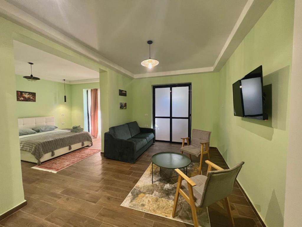 a living room with a bed and a tv on the wall at Hotel Florida in Durrës