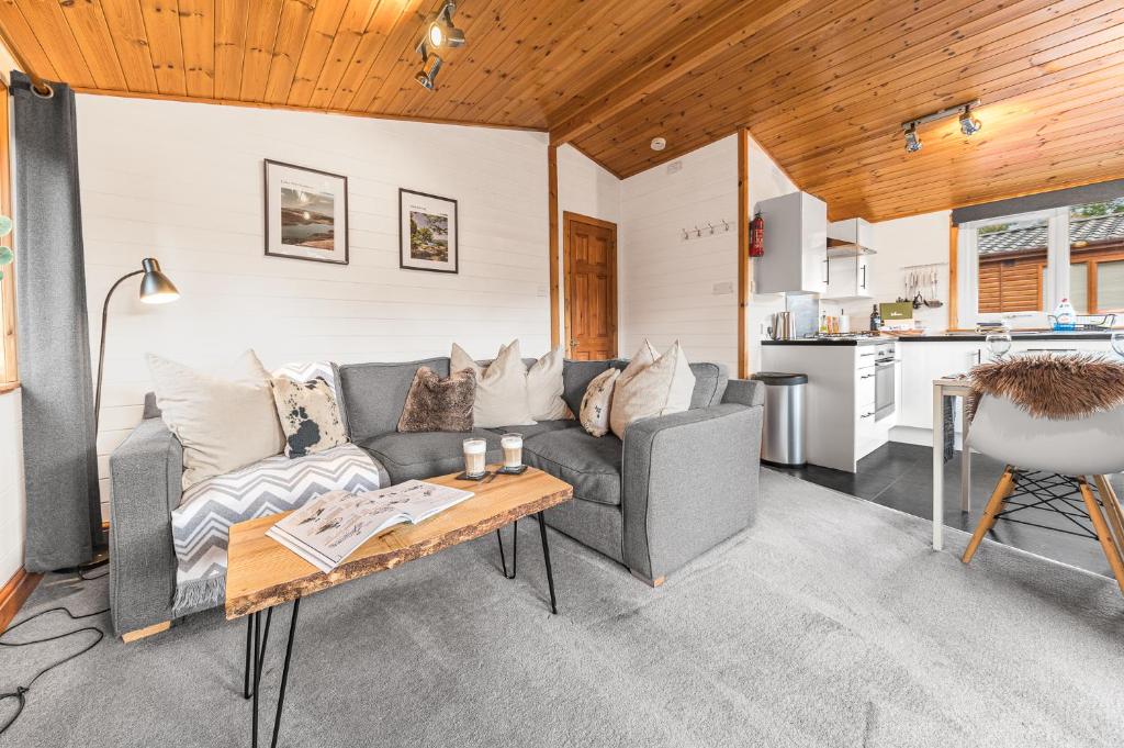 a living room with a couch and a table at Bowness 45 - 2 bedroom Lake Windermere Lodge in Windermere