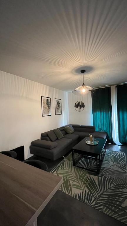 un salon avec un canapé et une table dans l'établissement Appartement vert, à Corbeil-Essonnes