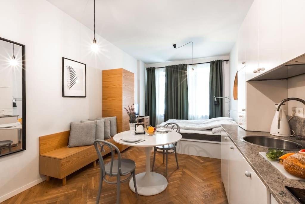kuchnia i salon ze stołem i krzesłami w obiekcie Cute Apartment perfect for business and travel. w Warszawie