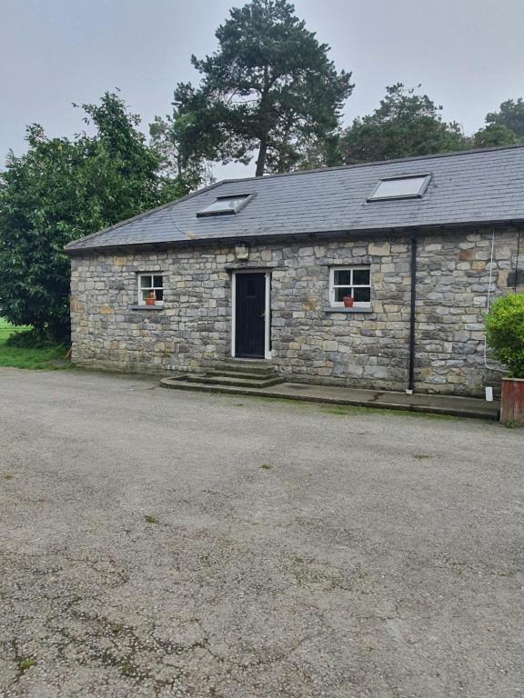 een stenen gebouw met een deur en twee ramen bij grange cottage 3 bedroom in Edenderry