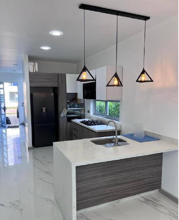 eine Küche mit einem Waschbecken und zwei Leuchten in der Unterkunft Hermosa casa Ricaurte in Girardot