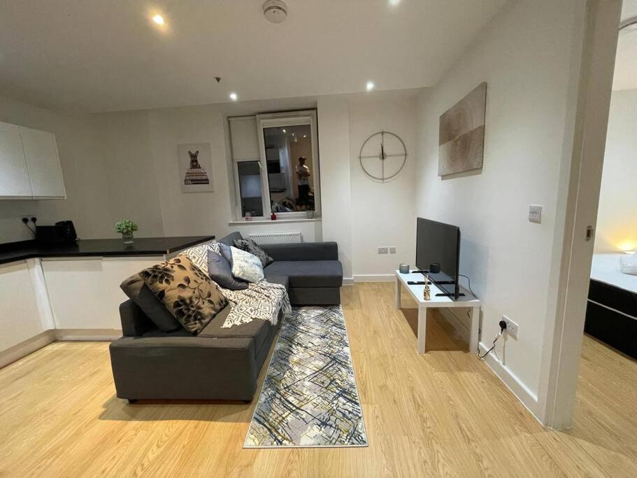 ein Wohnzimmer mit einem Sofa, einem Tisch und einem TV in der Unterkunft 1 Bedroom Flat in London CB46 in Croydon