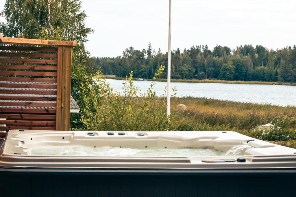 a white bath tub sitting next to a body of water at Tirmo Strand in Porvoo