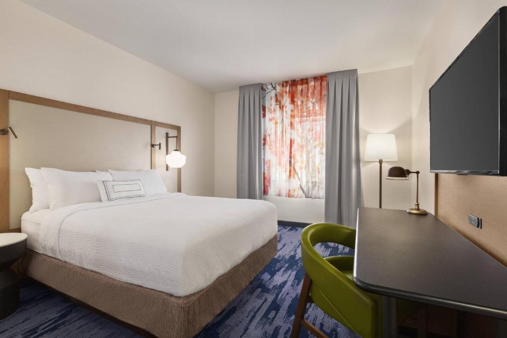 a hotel room with a bed and a desk at Fairfield Inn by Marriott Tracy in Tracy
