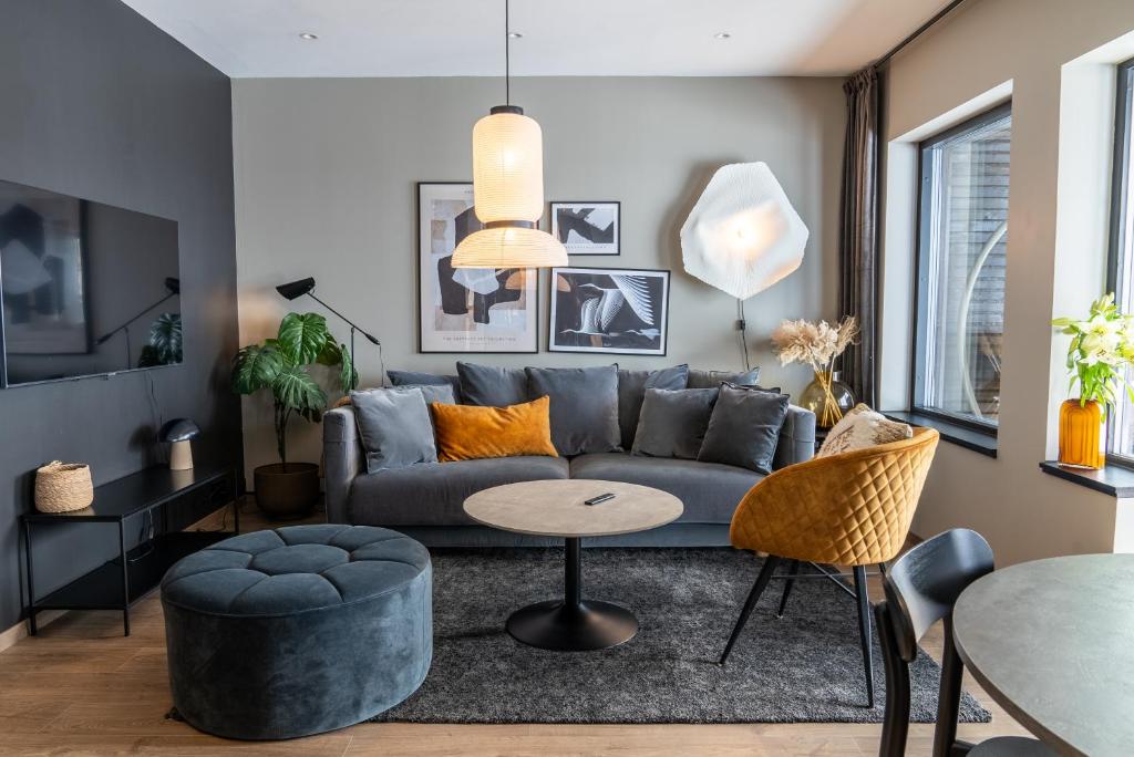 uma sala de estar com um sofá e uma mesa em Skipperhuset leilighet nr 4 em Tofta