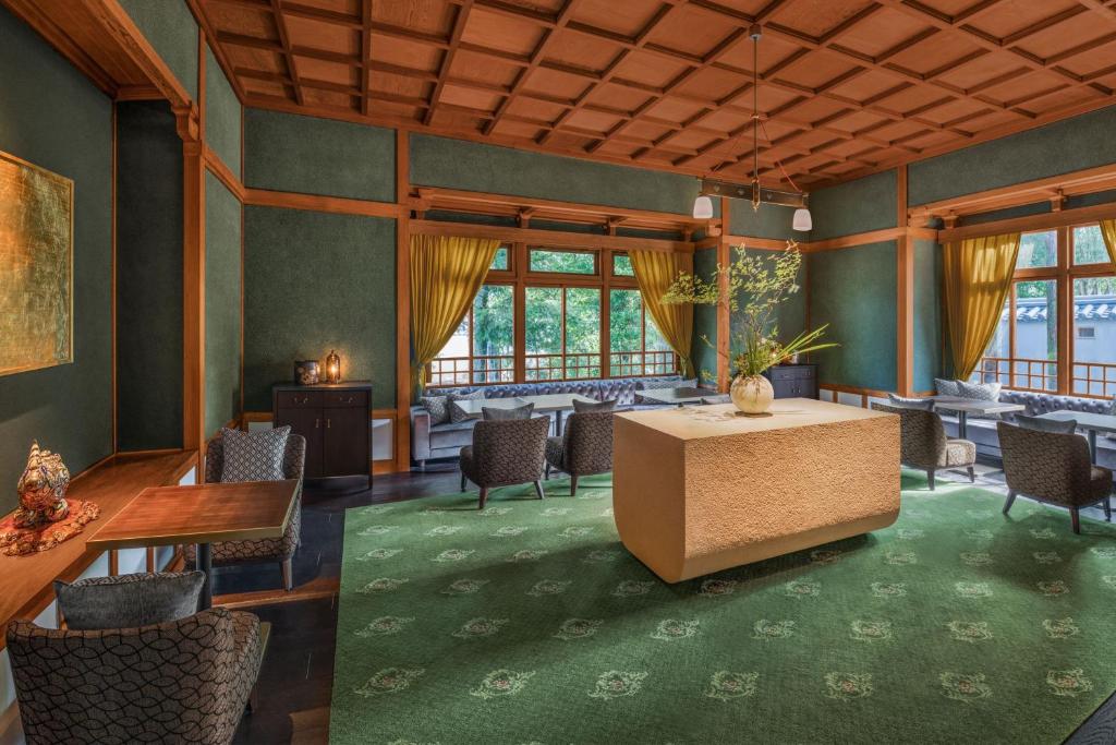 a room with a table and chairs and windows at Shisui, a Luxury Collection Hotel, Nara in Nara