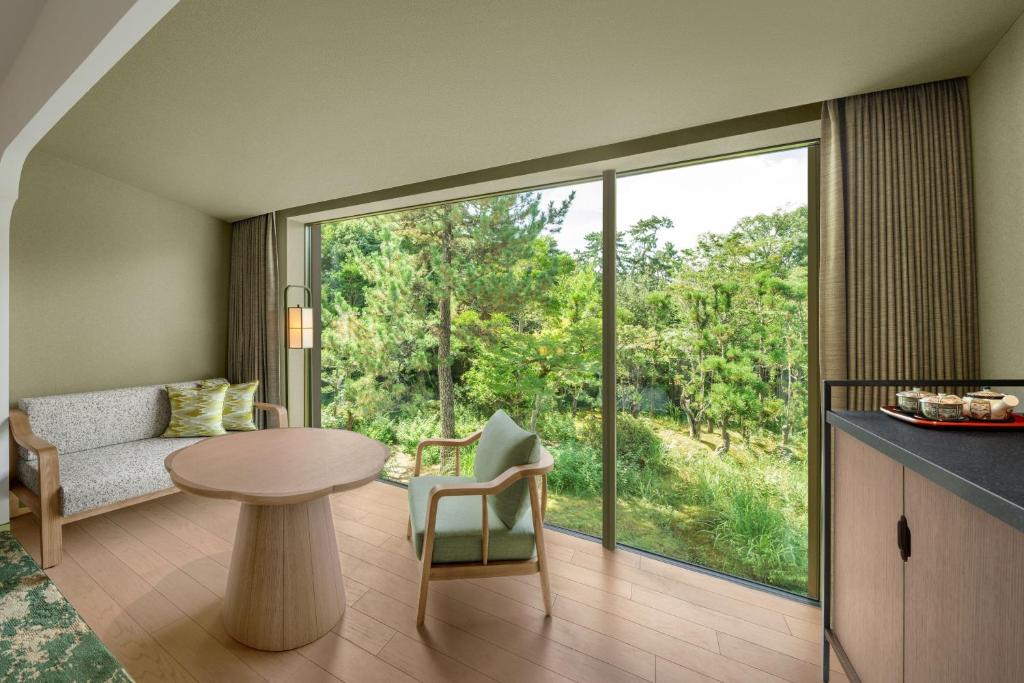 a living room with a table and a glass door at Shisui, a Luxury Collection Hotel, Nara in Nara