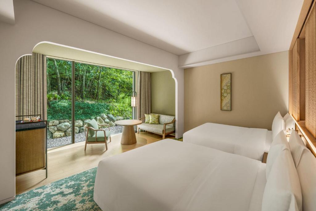 a hotel room with a bed and a large window at Shisui, a Luxury Collection Hotel, Nara in Nara