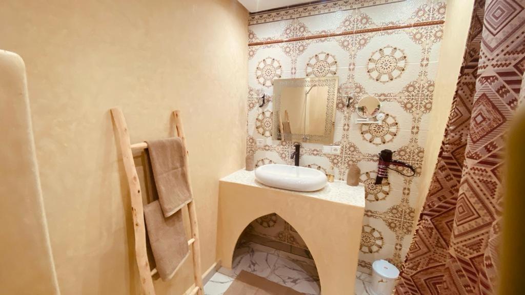 La salle de bains est pourvue d'un lavabo et d'un miroir. dans l'établissement SOUS LE SOLEIL Chez Jérôme et Pamela chambre Marrakchi, à Marrakech