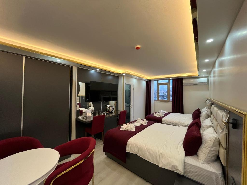 Lale Sultan Hotel في إسطنبول: غرفة فندقية بسرير وطاولة وكراسي