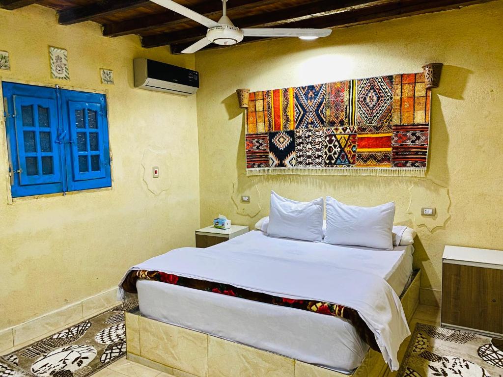 a bedroom with a bed and a blue window at خزفستا Khazfista in ‘Izbat an Nāmūs