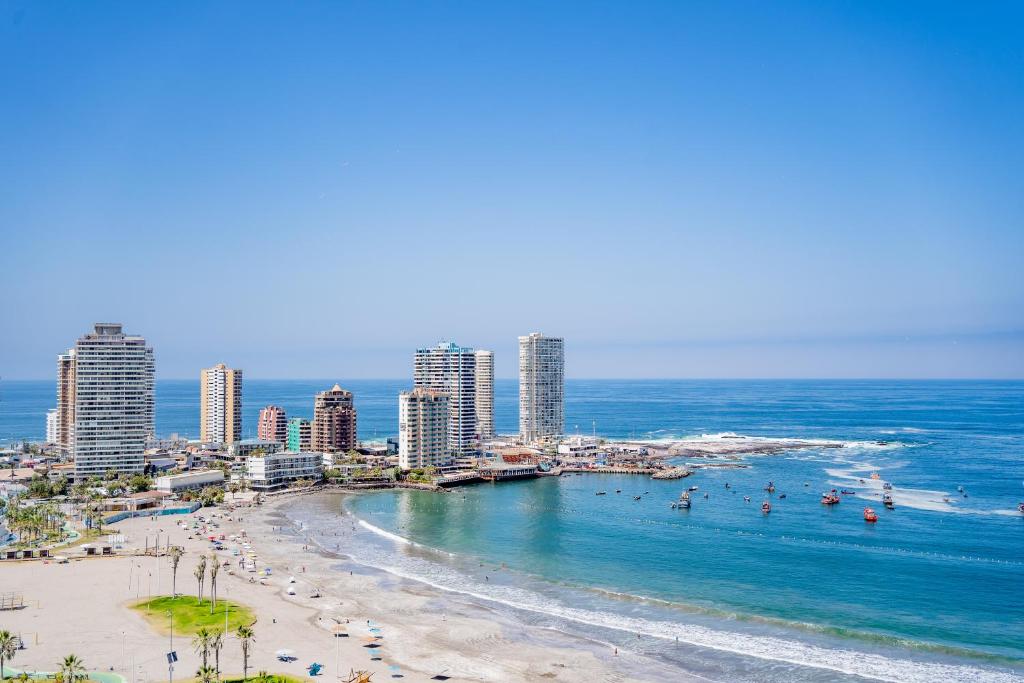 a view of a beach with buildings and the ocean at Departamento grande frente a playa Cavancha in Iquique